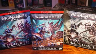 The three Warhammer 40K starter sets standing together on a wooden table