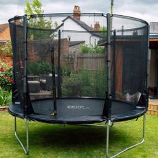 trampoline with netting in backyard on grass