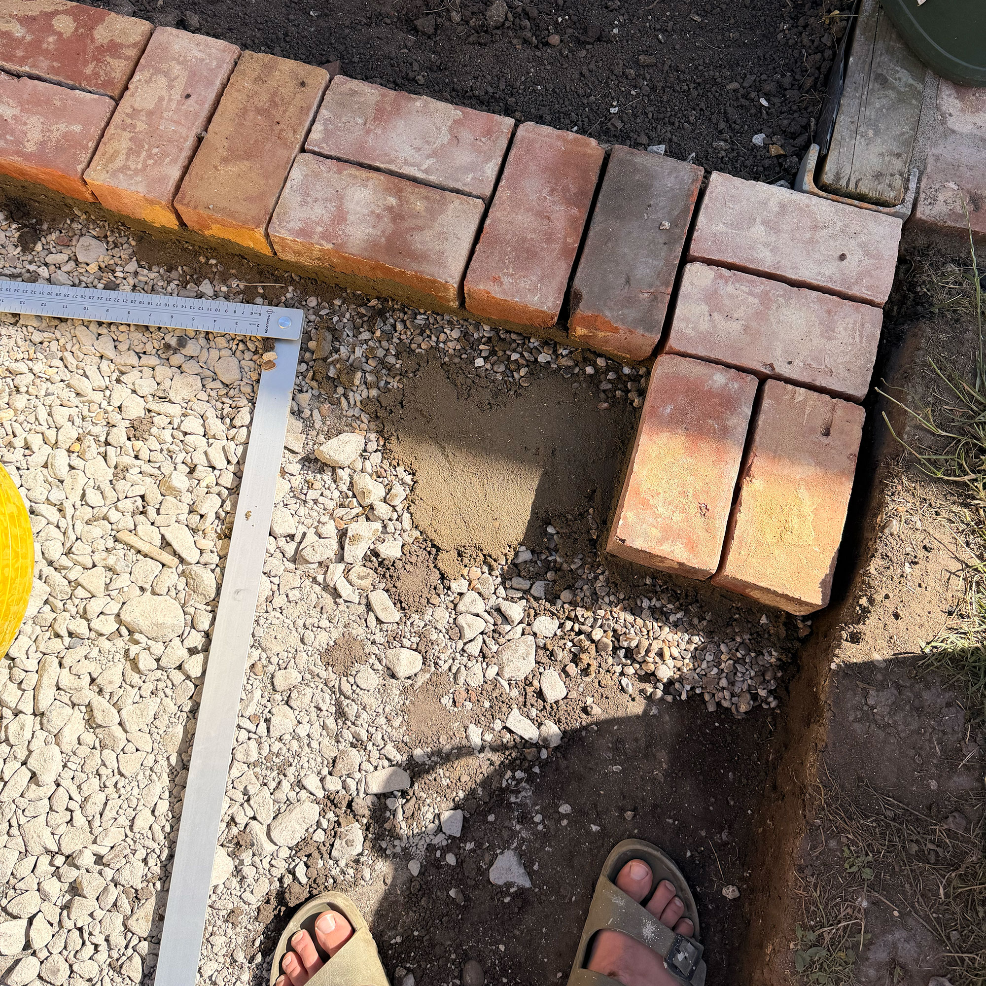 Garden border made of bricks mid-construction