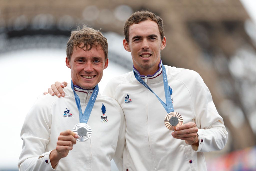Silver medallist France's Valentin Madouas (L) poses with bronze medallist France's Christophe Laporte (R) during the medal ceremony for the the men's cycling road race during the Paris 2024 Olympic Games in Paris, on August 3, 2024. (Photo by Odd ANDERSEN / AFP)
