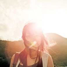 Mammal, Sun, Sunlight, Summer, Lens flare, Cap, People in nature, Light, Backlighting, Long hair, 