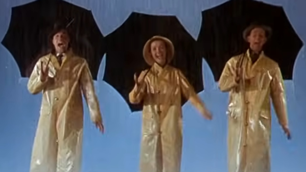 Gene Kelly, Debbie Reynolds, and Donald O'Connor wearing yellow raincoats in Singin' in the Rain