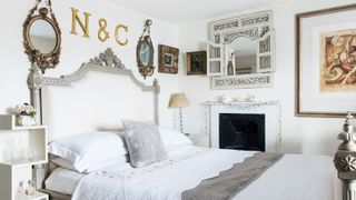 All white, French-style bedroom with gold accents and fireplace