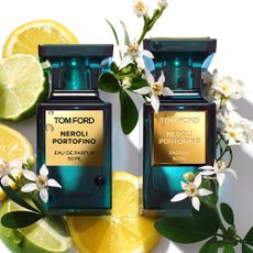 Two Tom Ford perfumes surrounded by a floral arrangement