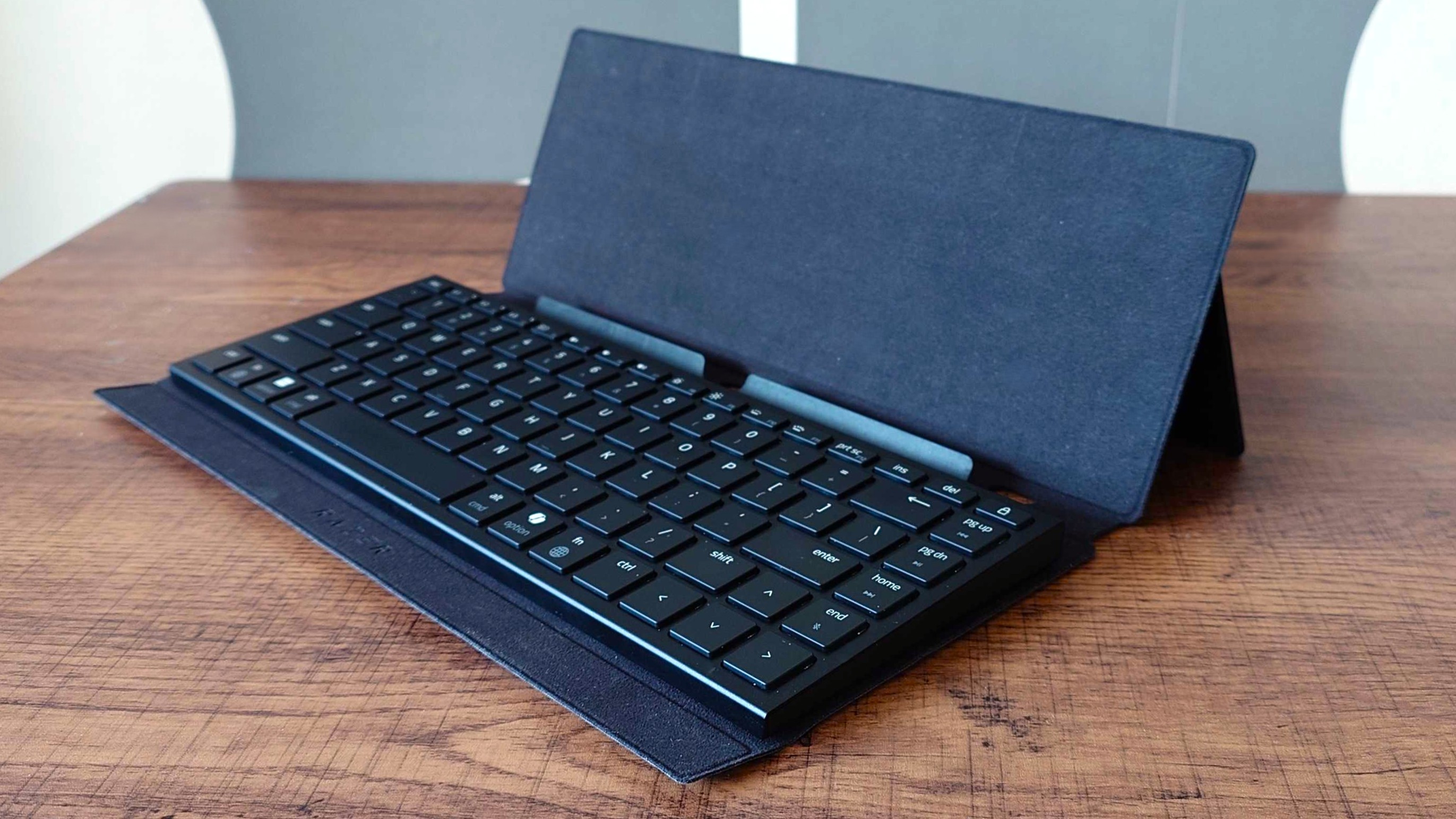 The Razer Travel Case Folio opened with a Razer Joro keyboard and the kickstand extended.