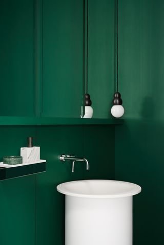 A bathroom drenched in dark green