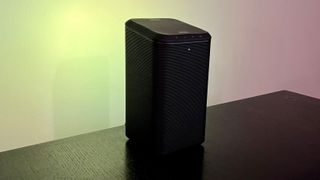 Philips Fidelio S1 speaker on black table with green background