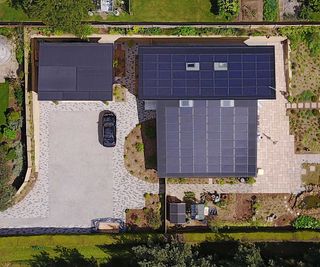 Aerial view of a large detached Passivhaus with solar PV panels covering the entire roof of the house