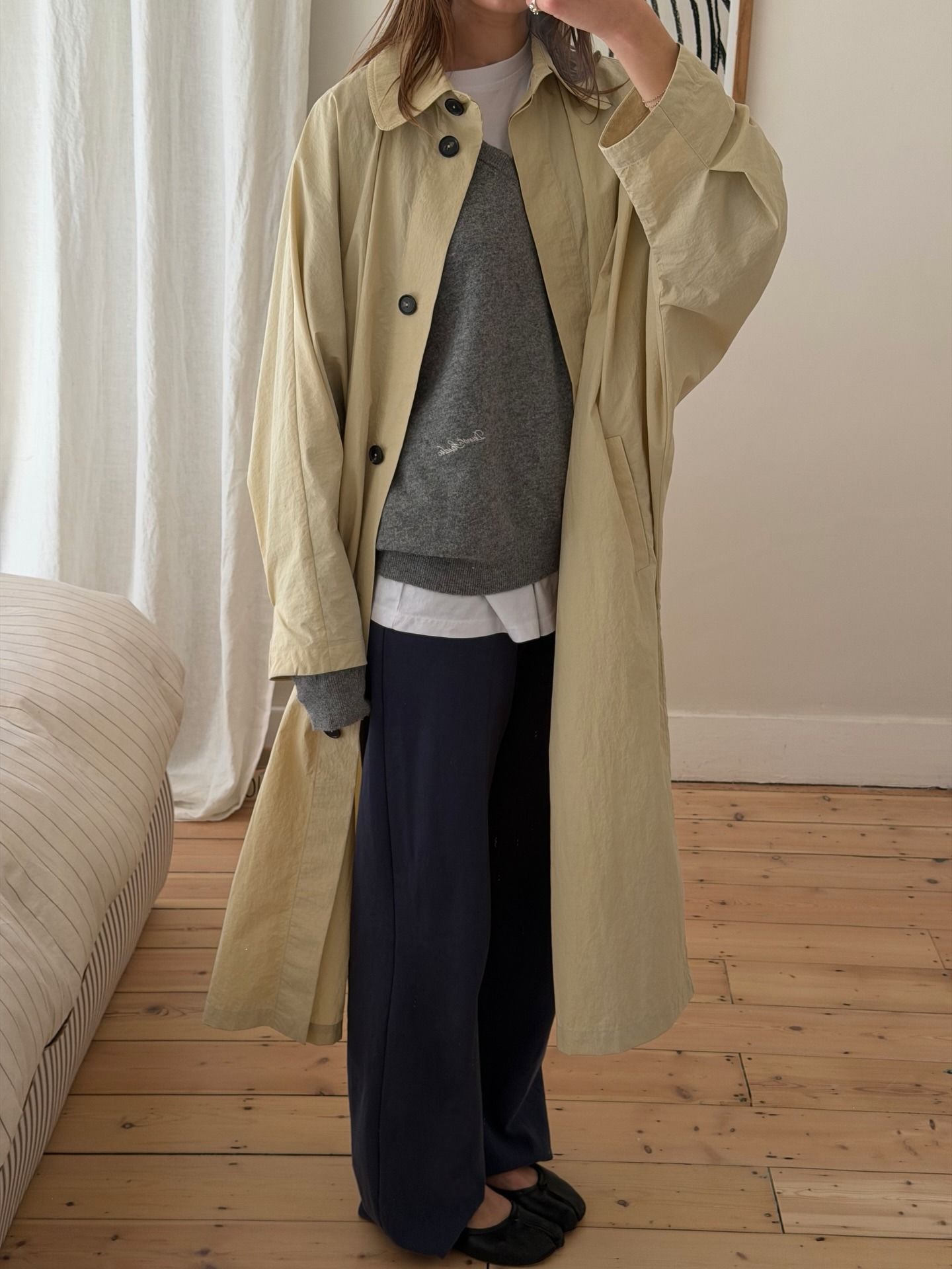 @poppyalmond wearing a trench coat, sweater, button-down, trousers, and ballet flats