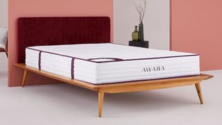 The Awara Natural Hybrid mattress shown in an orange bedroom