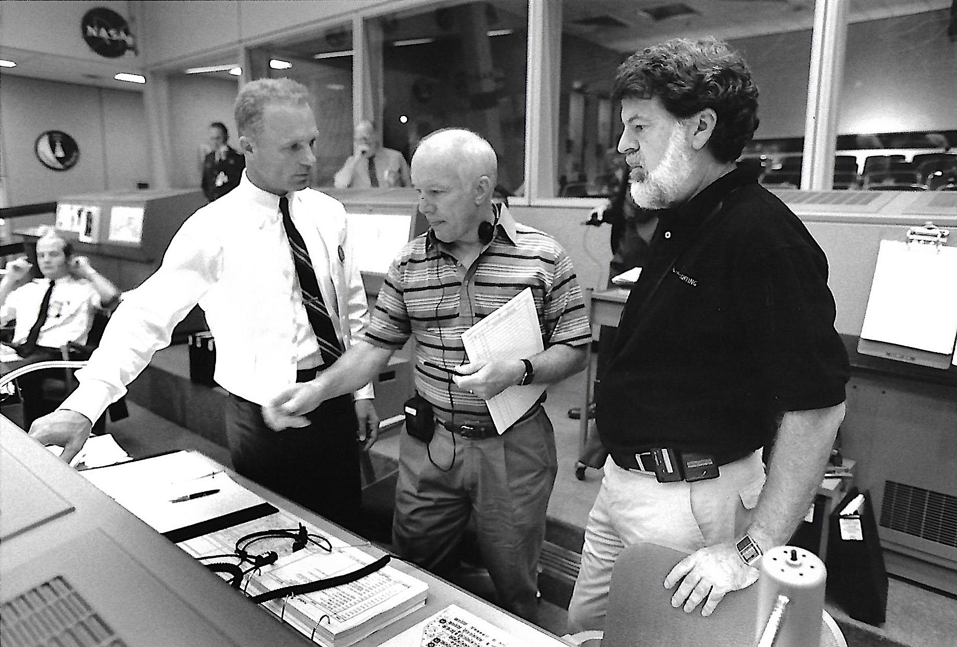 Three men on a movie set discussing a scene