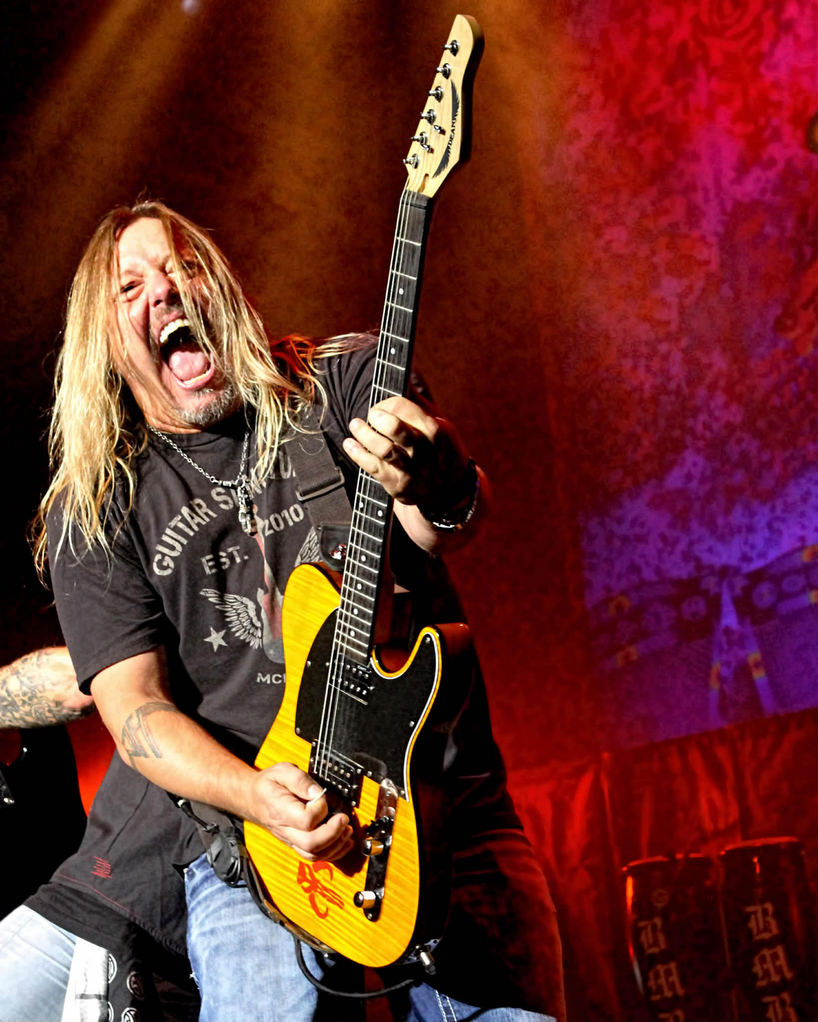 Pete Evick plays a yellow T-style Dean guitar onstage