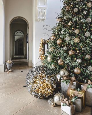 a christmas tree with buckets of gold and slver ornaments