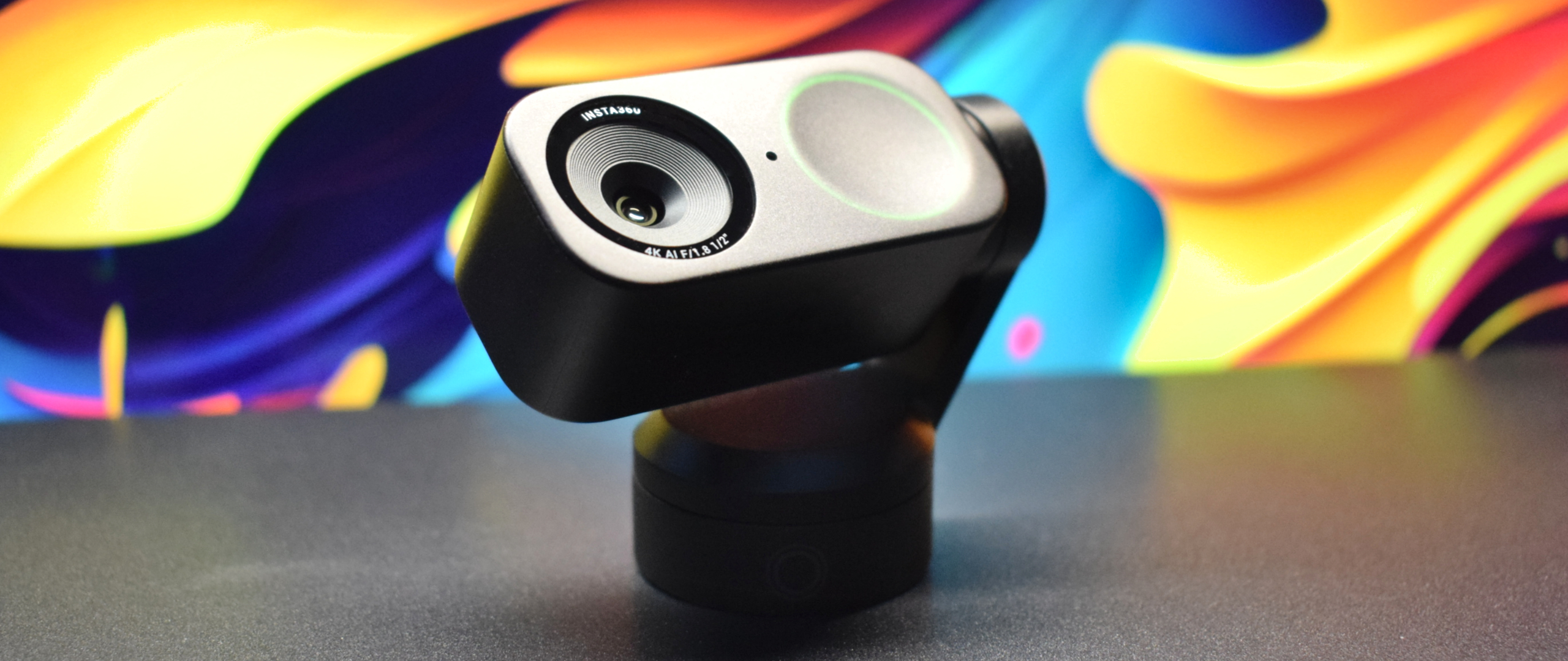Photo of the Insta360 Link 2 4k webcam showing a wide angle shot of the camera tilted up to highlight its front element (lens, pinhole microphone, and status light ring).
