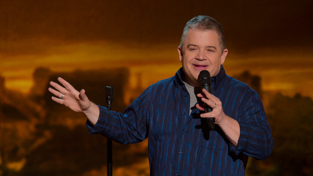 Patton Oswalt holding a microphone while telling a joke in Patton Oswalt: We All Scream.