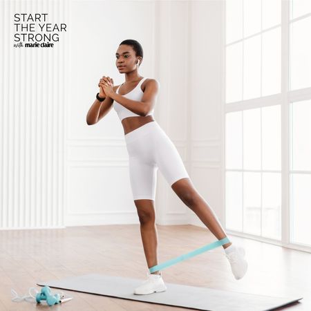 A woman doing advanced resistance band leg workouts at home on a yoga mat