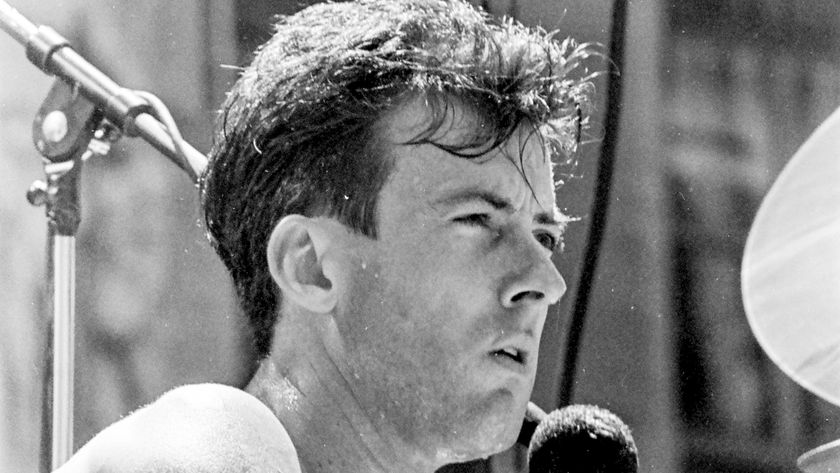  Rob Hirst, of the group Midnight Oil, plays drums as he performs in front of the Exxon Building (at Sixth Avenue &amp; 50th Street), New York, New York, May 30, 1990