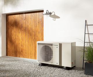 An air to air heat pump outside a home with a wooden garage door