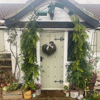 front door entrance with metal garden arch and heart shaped wreath