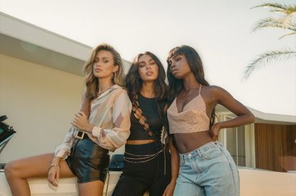 Three models wearing Princess Polly outfits standing in the sun