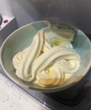 Thick ribbons of Vanilla bean soft serve ice cream in a green ceramic bowl made using the Cuisinart Soft Serve Ice Cream Maker
