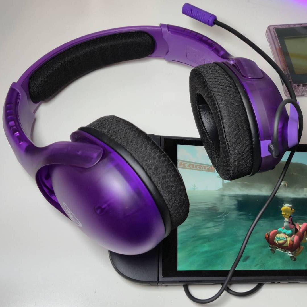 Photo by Rosalie Newcombe of the Ghost Purple Airlite Fit wired headset sitting on a Nintendo Switch 2.