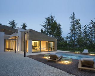 an outdoor space with a pool illuminated at night