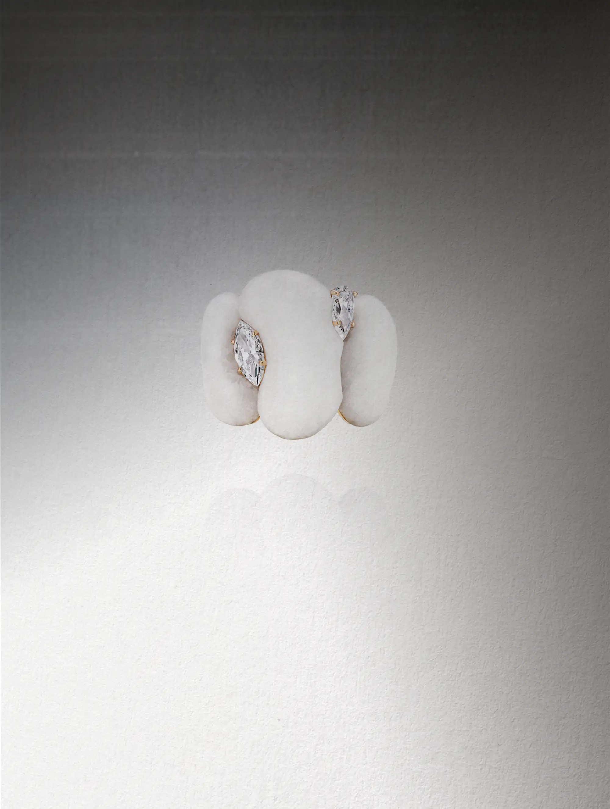 A white ring studded with diamonds called the High Fluid Pebbles ring by Fernando Jorge