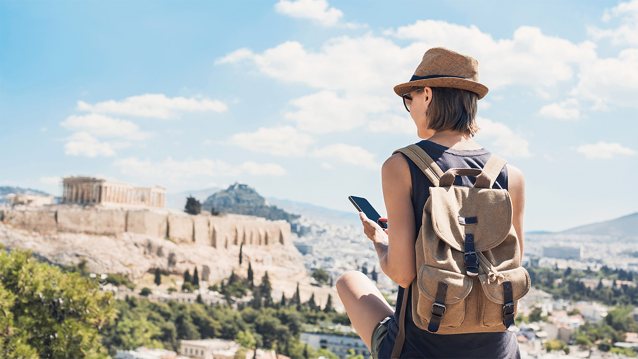 Person holding smartphone on hillside in Greece