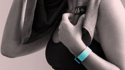 Woman wearing a fitness tracker on her wrist.