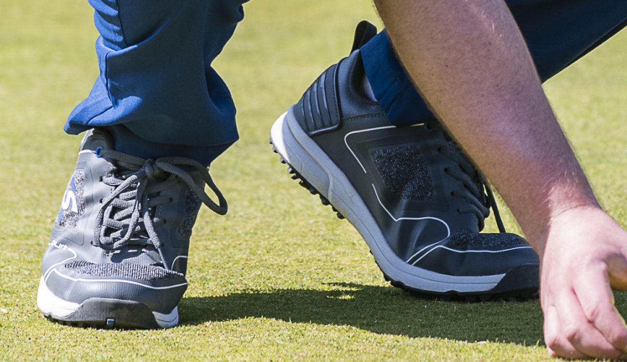 The Stuburt XPII Spiked Golf Shoe bends as the player lines up a putt