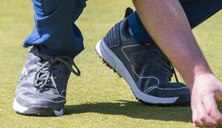 The Stuburt XPII Spiked Golf Shoe bends as the player lines up a putt