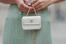 Quilted white leather mini bag with flap closure, gold-tone CC logo, and chain strap by Chanel is seen