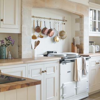 country kitchen with cream cabinetry and walls with white aga