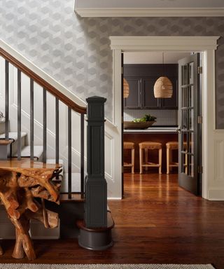 An entryway with hardwood floors, a stairway, and a natural wooden console table