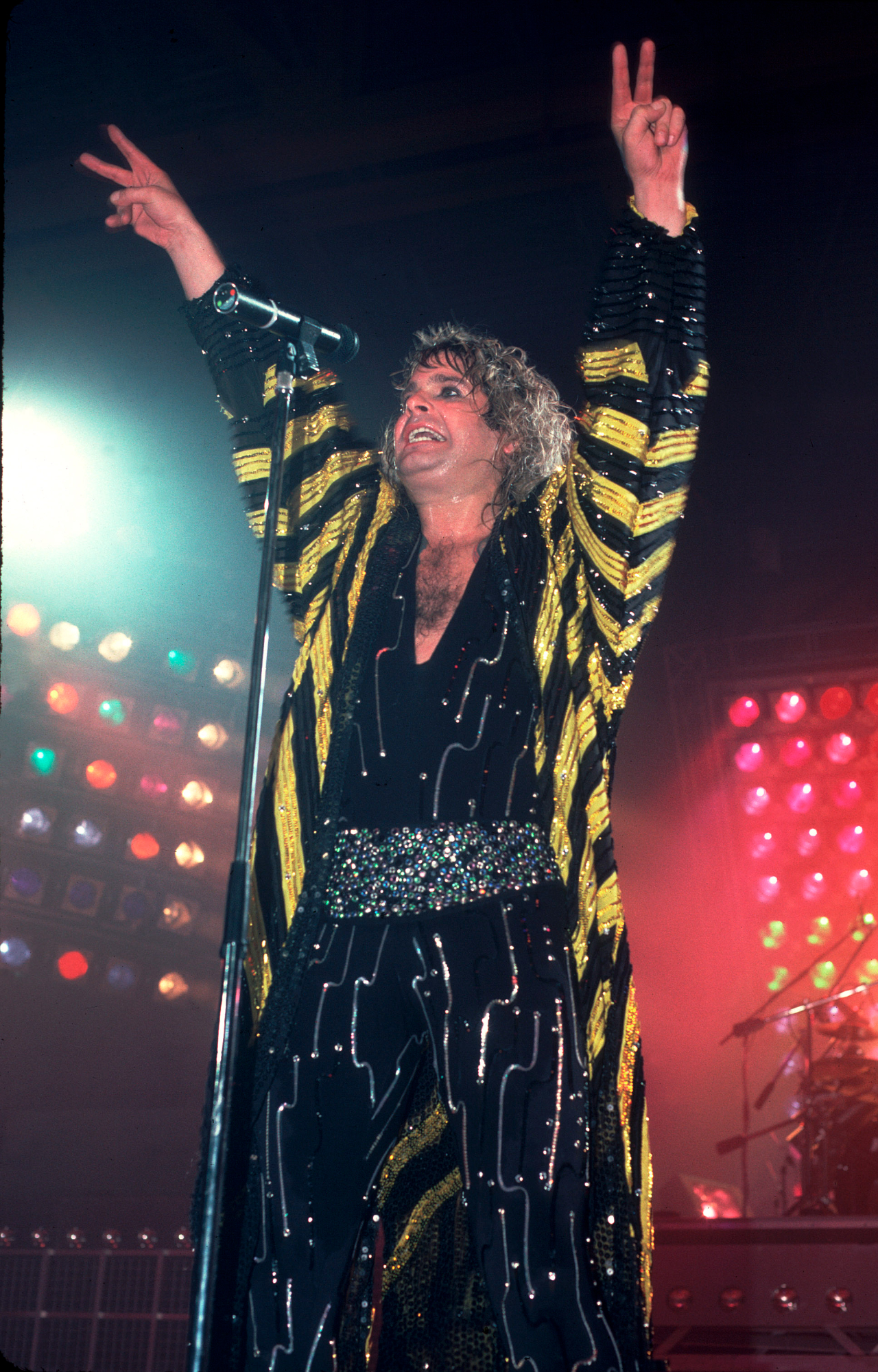 Ozzy on stage with his arms raised in 1986