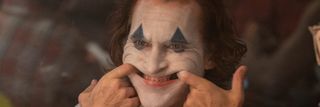 Arthur Fleck smiling in the mirror in Joker