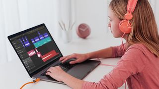 Girl wearing pink top using Soundation on a laptop