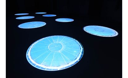 Illuminated blue circles on black background, installation view of Turner Prize 2021 exhibit by Cooking Sections