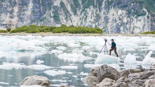 Man using a video tripod on an icy lake