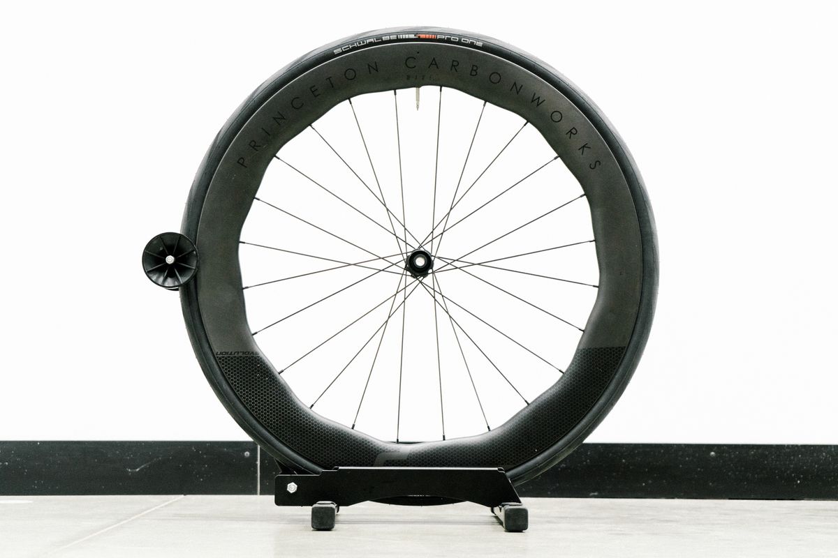 An aero road wheel stands against a white wall