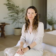 A portrait of Jenni Kayne surrounded by her own home goods products.