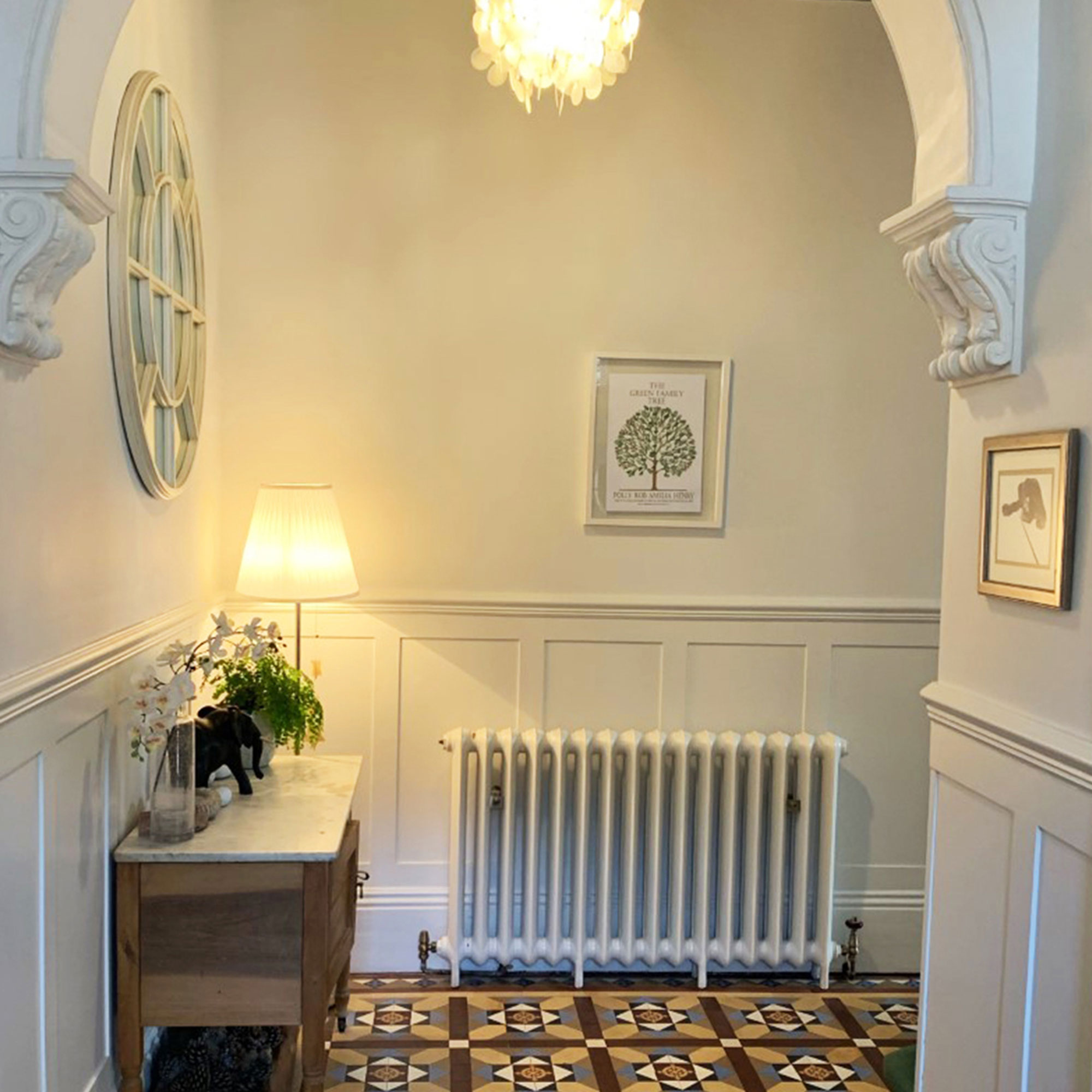 white cast iron column radiator in hallway with wall panelling