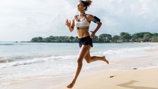 Woman running barefoot on beach