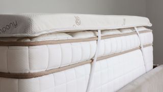 A closeup of the Saatva Graphite Memory Foam mattress topper on a bed
