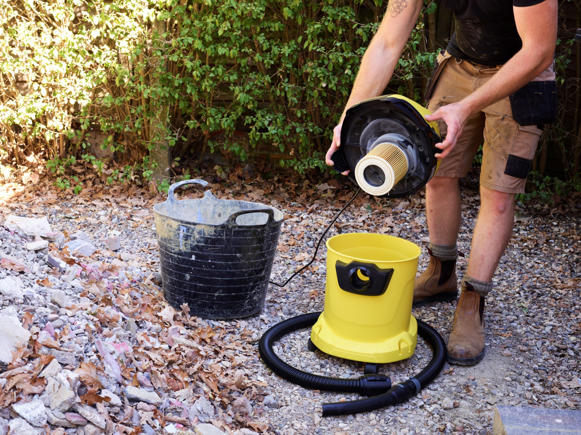 A builder inspects the filter of a Karcher WD vacuum cleaner