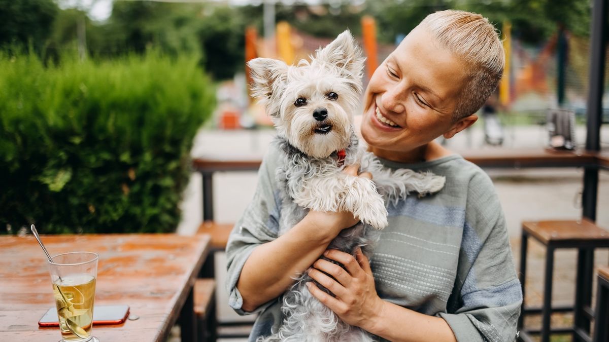 Woman and dog enjoying time together at a cafe