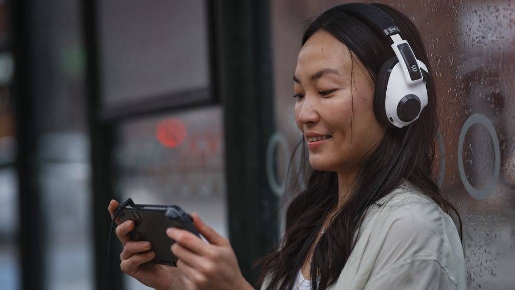 Woman playing Nintendo Switch while wearing the Epos H3 Hybrid