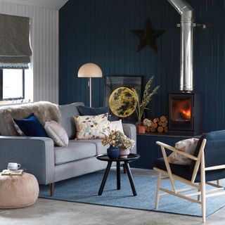 living room with navy wall and pillows on grey sofa