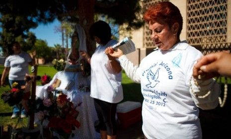 Protesters opposed to Arizona&amp;#039;s controversial Immigration law hold hands during a vigil held at the state Capitol ahead of the Supreme Court&amp;#039;s hearing this week.